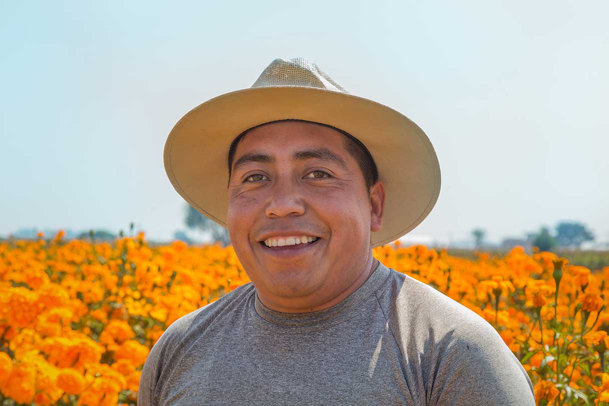 Smiling man standing in front of a field of flowers