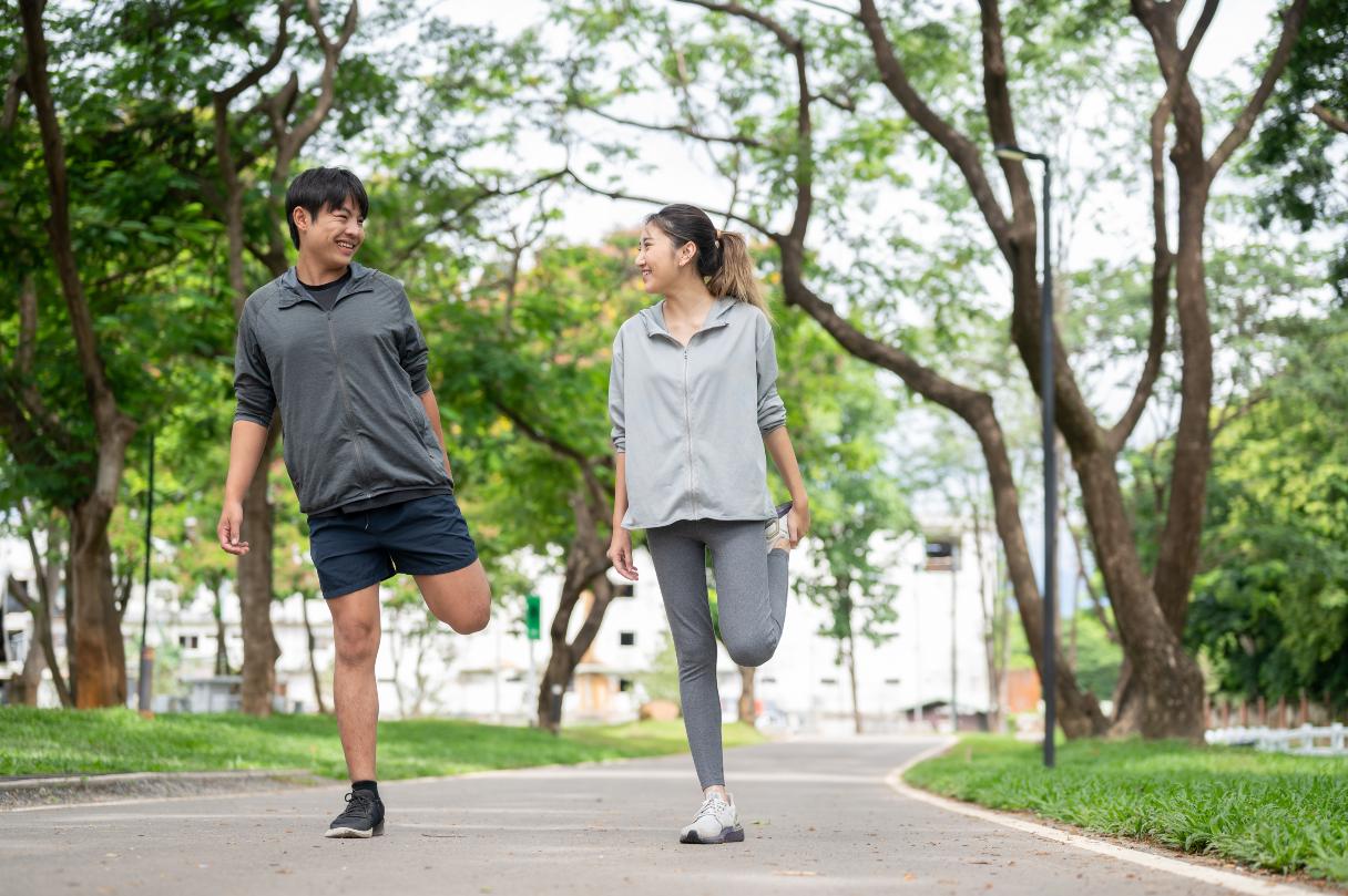 Man and woman stretching their legs outside
