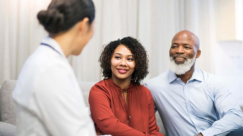 Doctor speaking with two patients