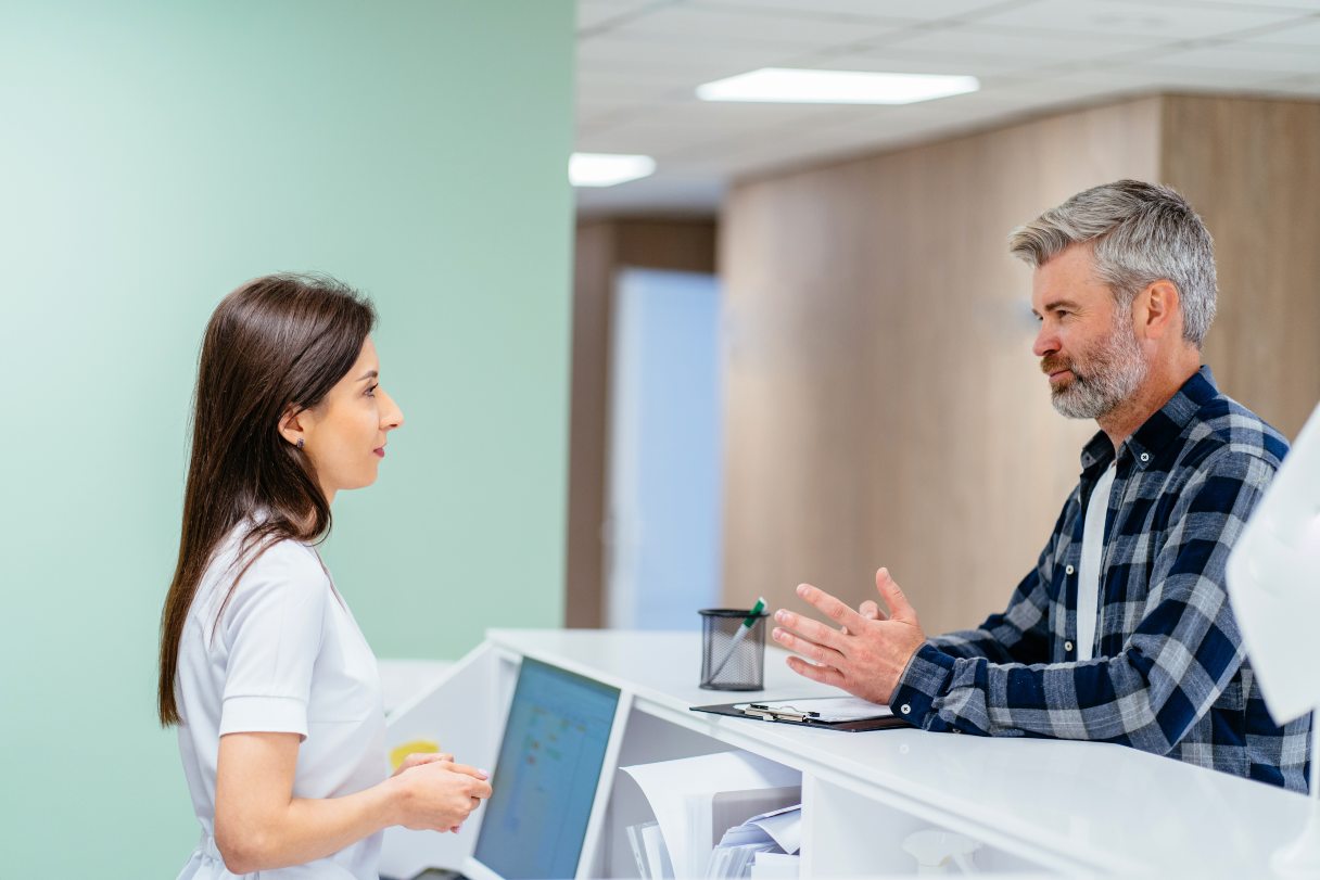 Medical receptionist speaking with patient