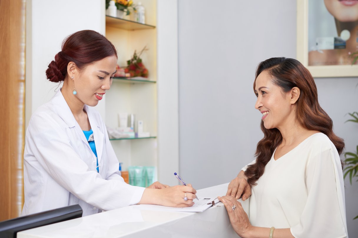 Woman speaking with healthcare receptionist