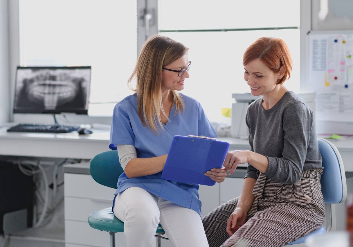Dental professional showing patient a clipboard