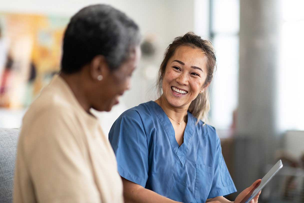 Healthcare professional showing client a tablet device