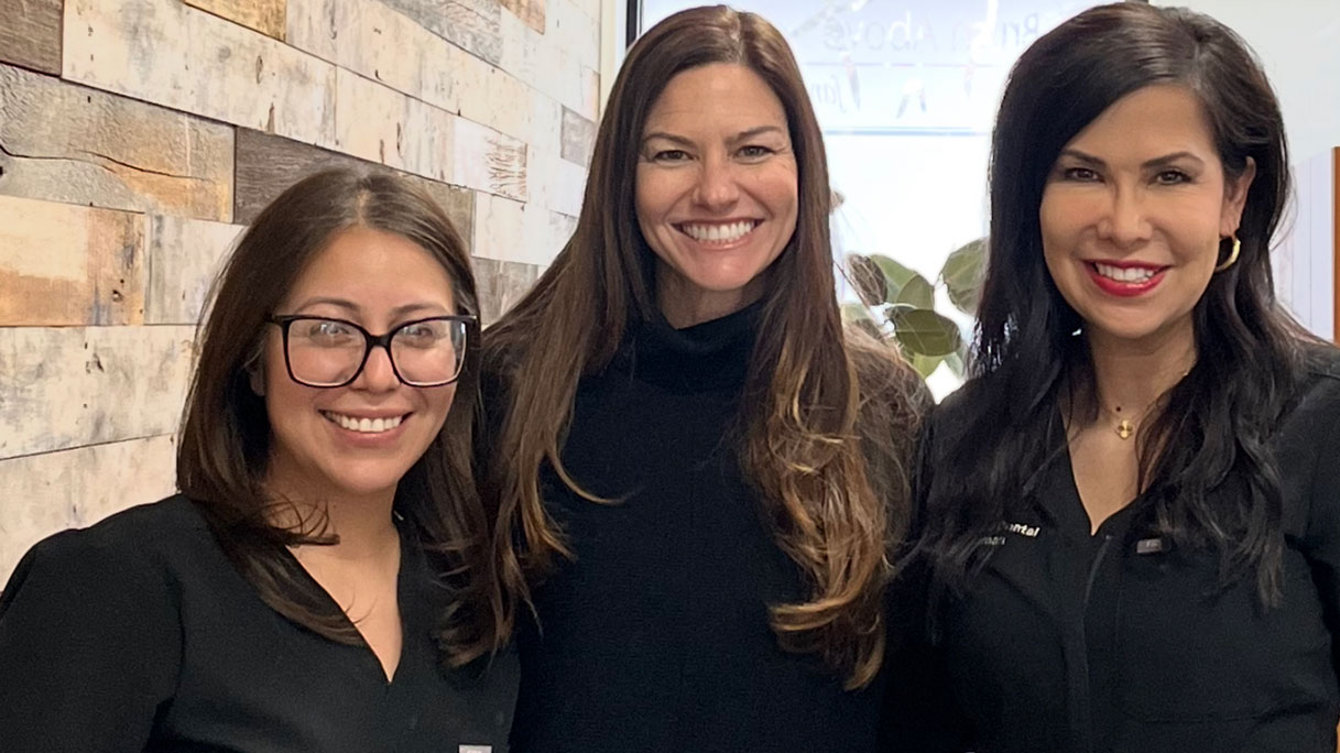 Three women, all smiling