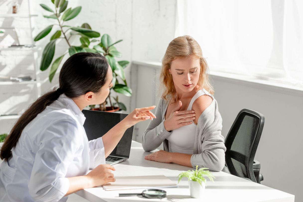 Doctor looking at woman's shoulder